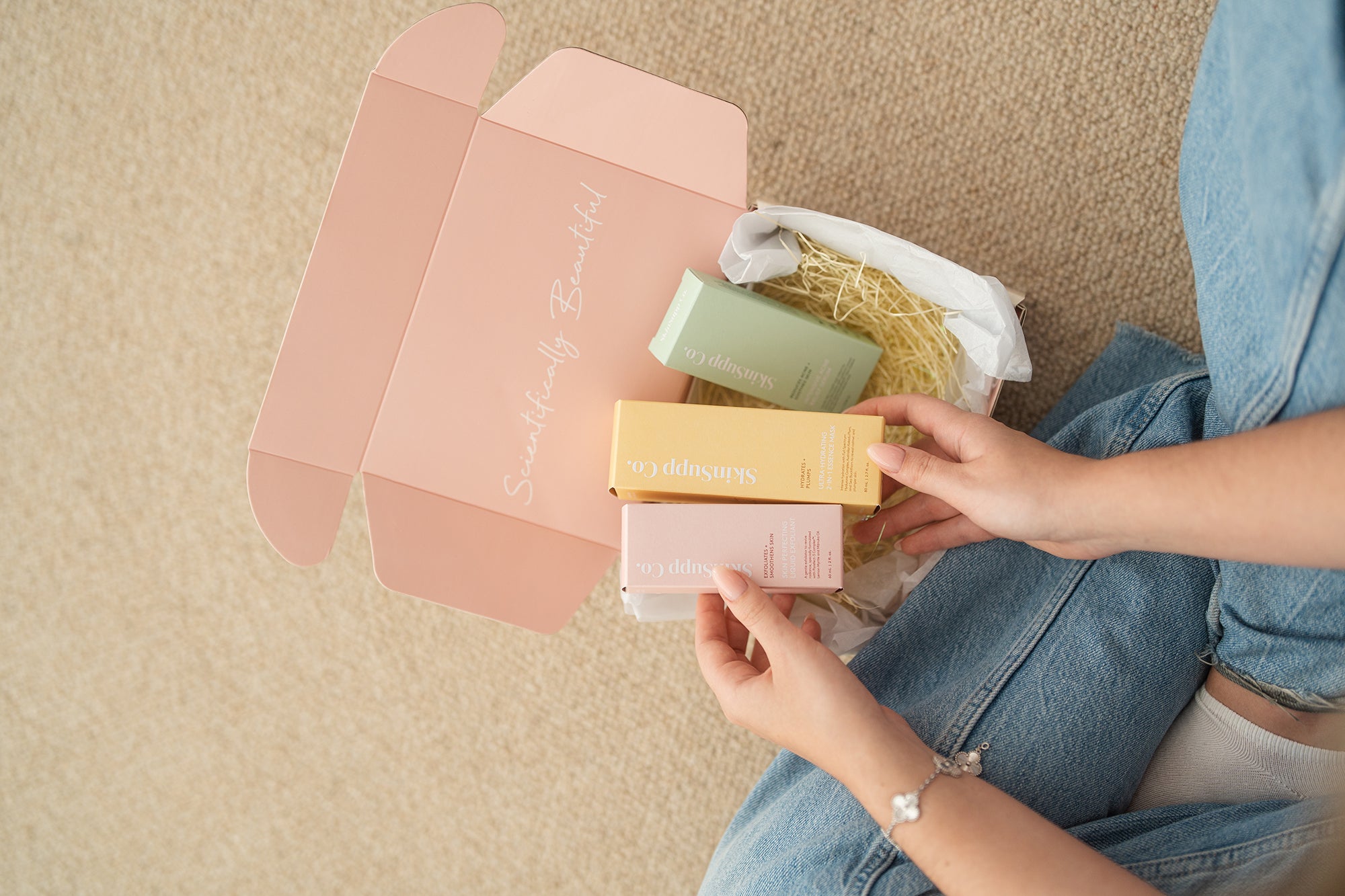 Woman holding a box of SkinSupp Co. products
